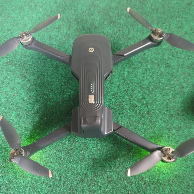 Black quadcopter drone with four propellers and central controller body