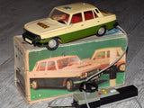 Vintage toy car model of a cream-and-green station wagon with red interior and wheels