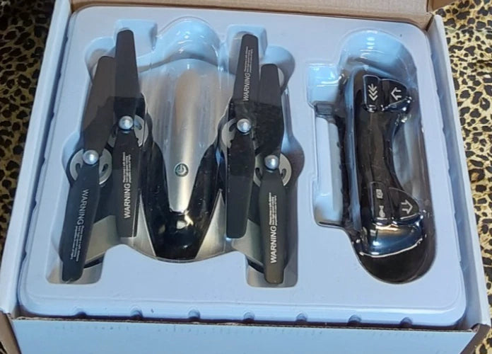 Foldable quadcopter drone with built-in HD camera, shown in packaging.