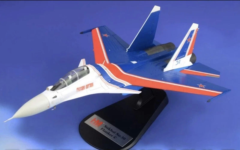 Blue and orange 1:72 scale Su-30SM model aircraft on black display stand