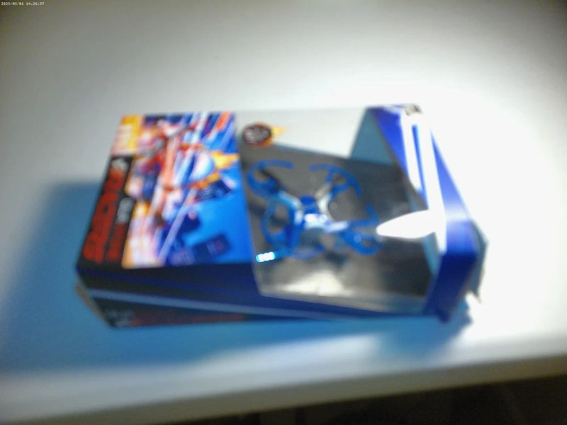 Blue quadcopter racer drone with propellers visible on a tabletop
