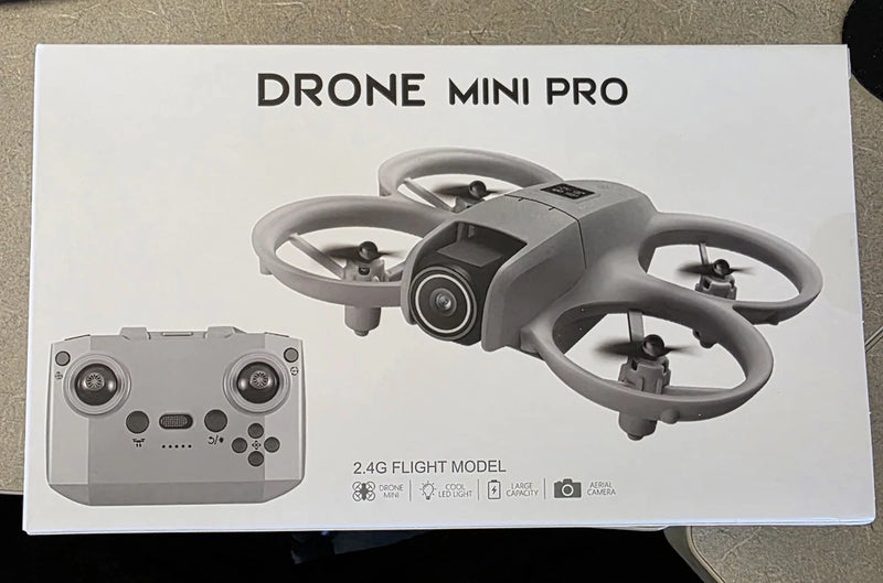 Gray ready-to-fly mini drone with foldable quadcopter arms and controller remote.