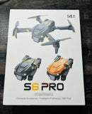 Foldable quadcopter drone box showing black and orange drone views