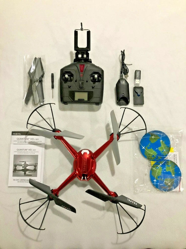Red quadcopter drone parts kit with controller, propellers, and manuals
