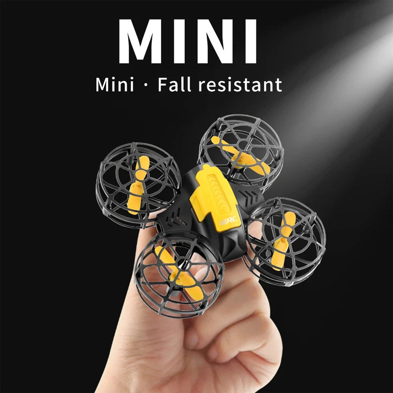 Mini RC quadcopter drone toy with four propellers and yellow accents, held in hand