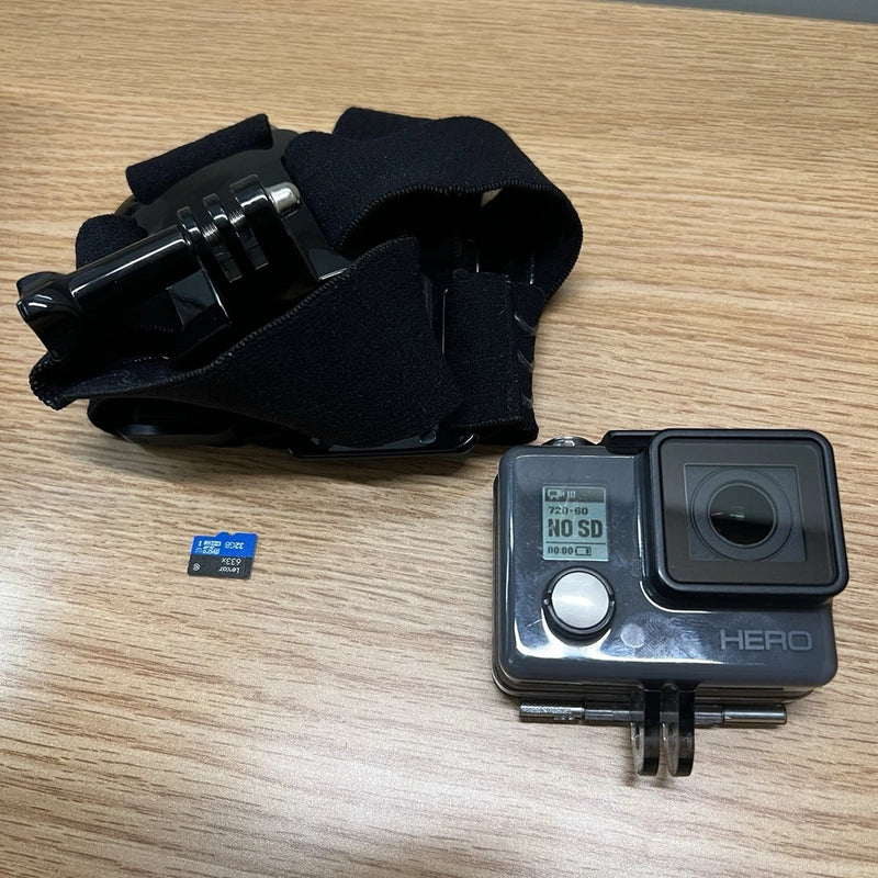Gray action camcorder with front lens, HERO logo, in clear protective housing and mounting bracket