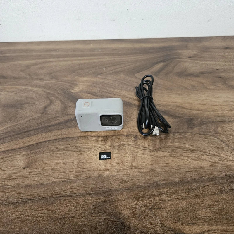 GoPro Hero 7 White action camera with lens, USB cable, and microSD card