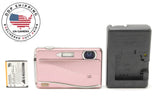 FUJIFILM pink compact digital camera with lens, side buttons, and open battery compartment