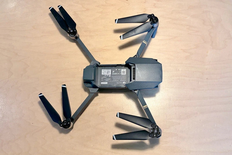 Grey quadcopter drone with four propellers, compact foldable arms