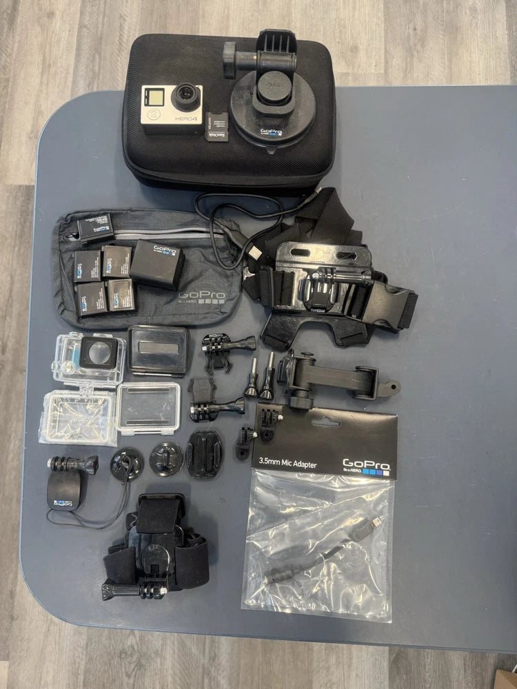 Silver action camera kit with case, mounts, waterproof housing, and accessory parts