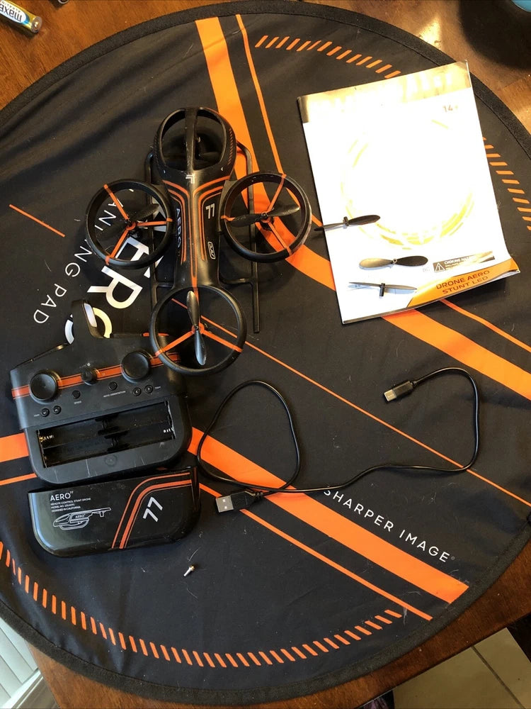 Sharper Image aero drone kit with controller, orange drone, and connecting cables