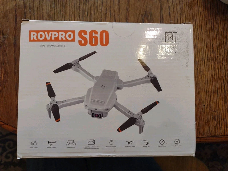 Gray quadcopter drone with camera, shown on retail box packaging