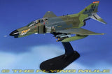Camouflage F-4E Phantom II model aircraft on display stand, gray-green with missiles