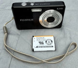 Black Fujifilm compact digital camera with lens and included battery and wrist strap.