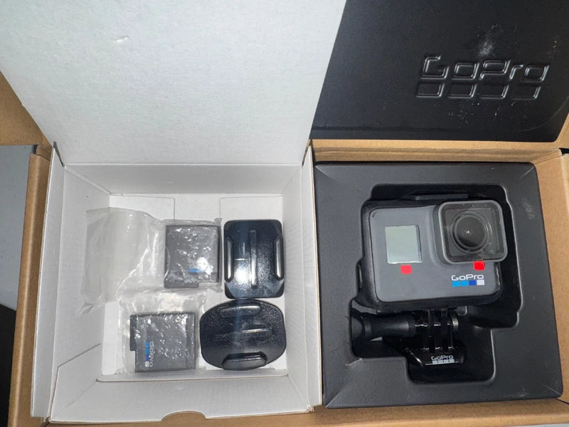 Black GoPro HERO action camera with housing and mounting accessories in retail box