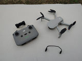 DJI Mini 2 SE camera drone and gray controller with green status lights