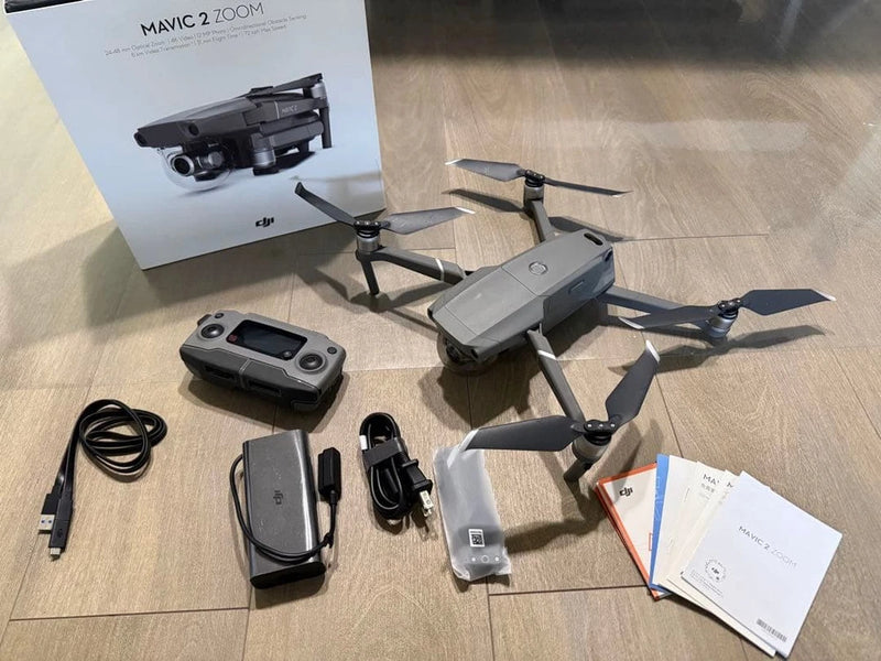 Foldable quadcopter drone kit with remote controller, charger, cables, and manuals