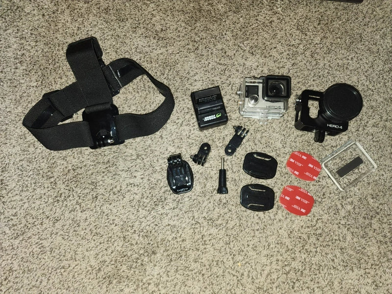 GoPro HERO 4 action camera kit with head strap, mounts, battery, and cases
