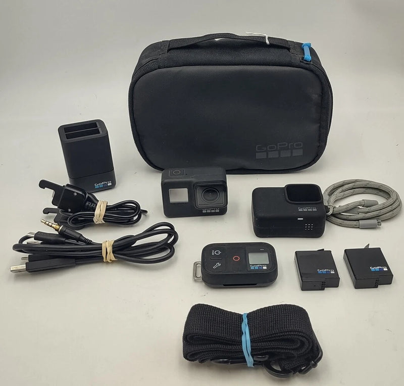 Black GoPro action camera accessory kit with protective case, cables, batteries, mounts