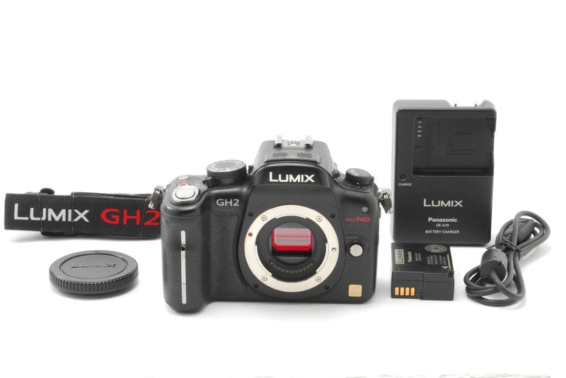 Black Panasonic Lumix GH2 mirrorless camera with lens cap, battery, charger