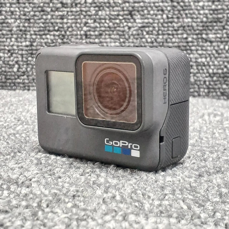 GoPro HERO6 action camera, gray body with front lens window and side buttons.