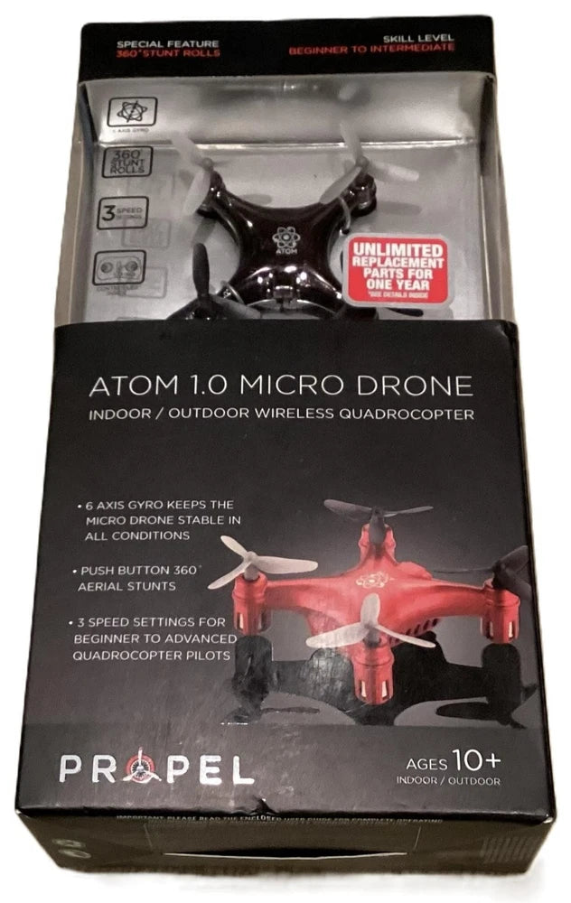Black micro quadcopter drone in retail box with four propellers visible.