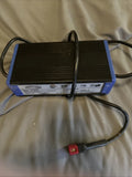 Blue and black 24V battery charger with attached power cables and red connector plug