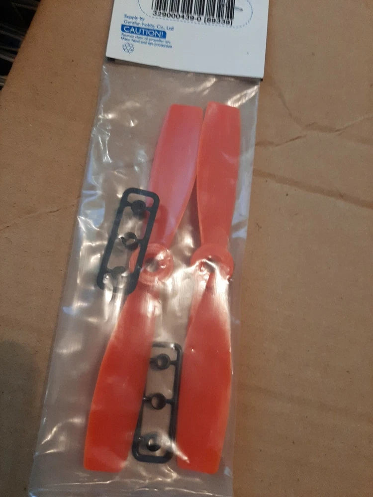 Red two-blade drone propeller set in clear sealed bag