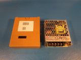 Enclosed AC/DC converter with orange cover and vented metal housing, electrical terminals on front
