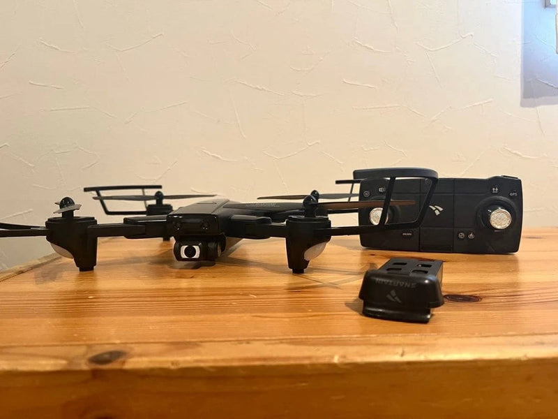 Foldable GPS FPV drone with camera and black controller, on a tabletop