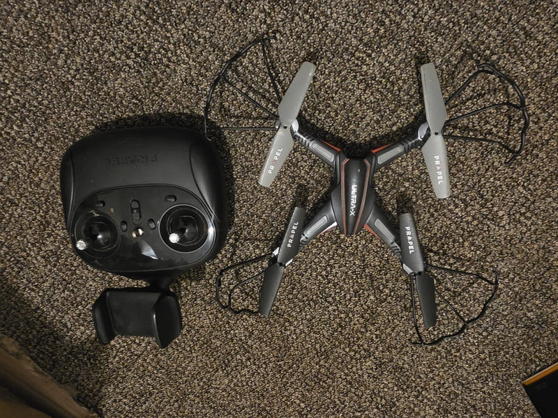 RC video drone with controller, gray and black quadcopter with four propellers