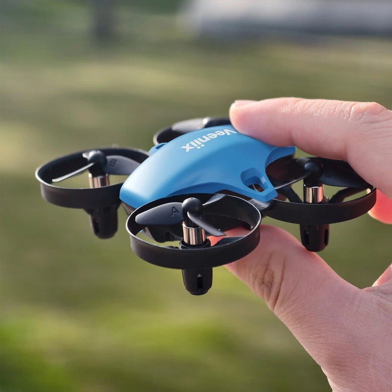 Blue mini quadcopter drone with prop guards, held in hand