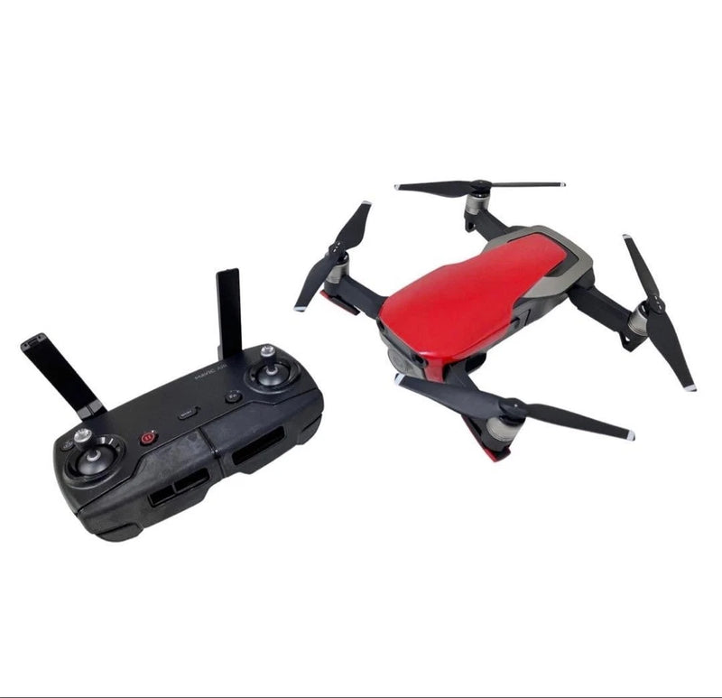 Foldable quadcopter drone with red body and black remote controller, four propellers