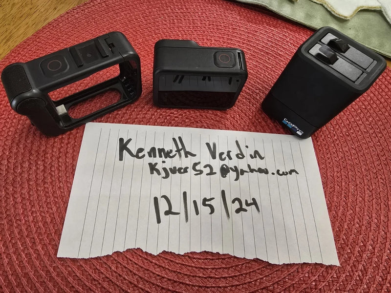 Black action camera battery pack and mounting housings, close-up