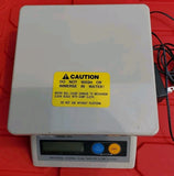 Digital kitchen scale with LCD display, buttons, and caution label
