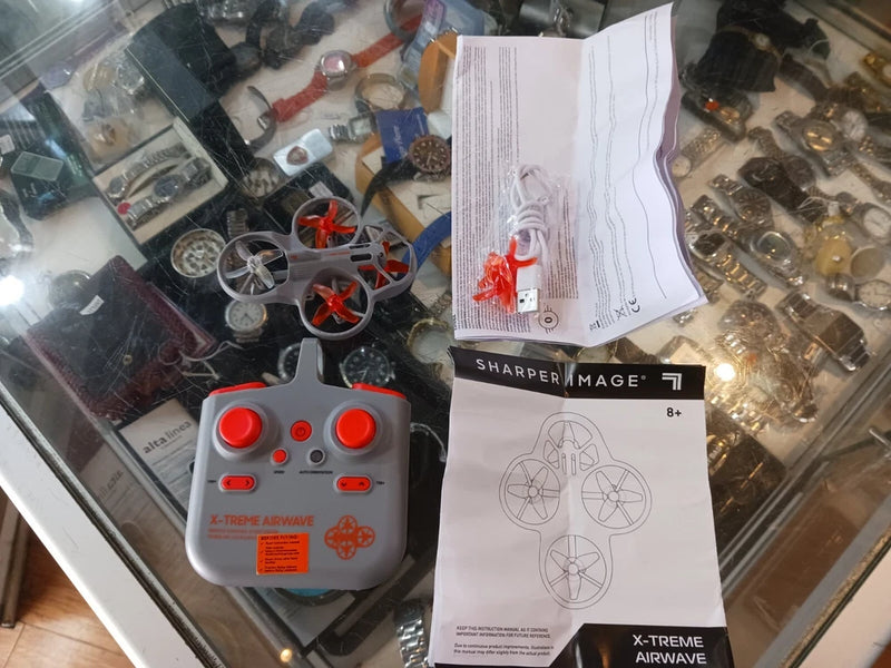 Mini RC stunt drone set with gray remote controller and red propellers.