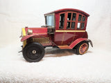 Red vintage tin battery-operated Model T toy car with black wheels, side view