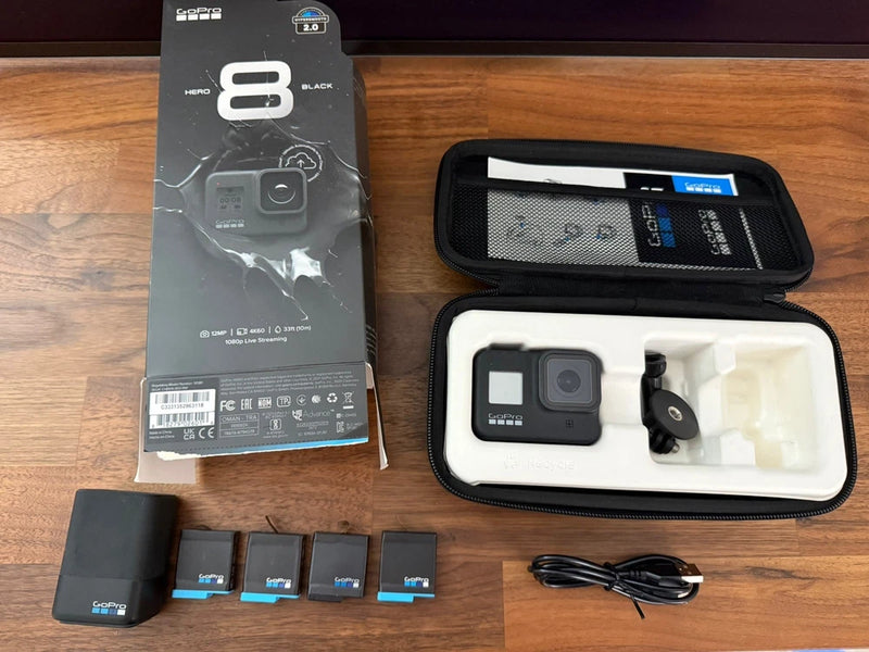 GoPro action camera kit with black case, open camera, batteries, and USB cable.