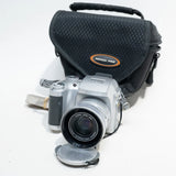 Fujifilm FinePix S3500 digital camera with silver body, front lens, and black carrying case