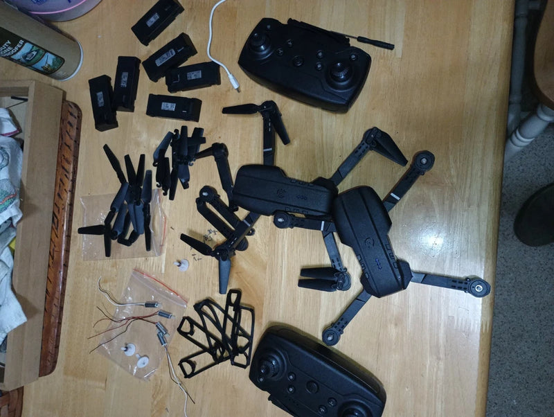Used E88–E99 PRO drone parts lot with multiple black frames, arms, and propeller mounts