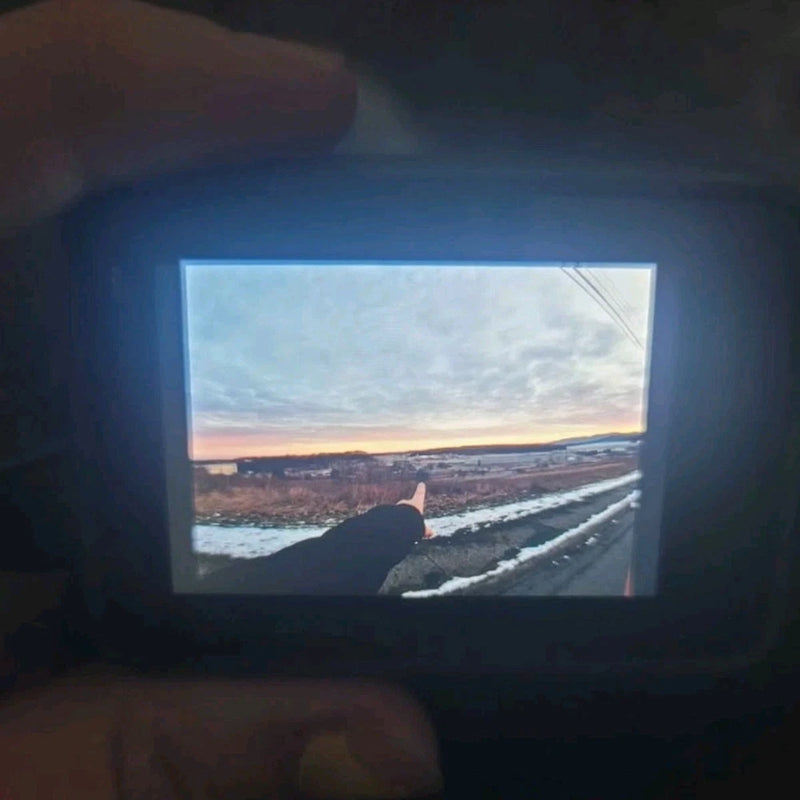 GoPro HERO7 action camera with lit touchscreen display showing a landscape