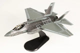Black and gray F-35C model jet on black display stand, angled view