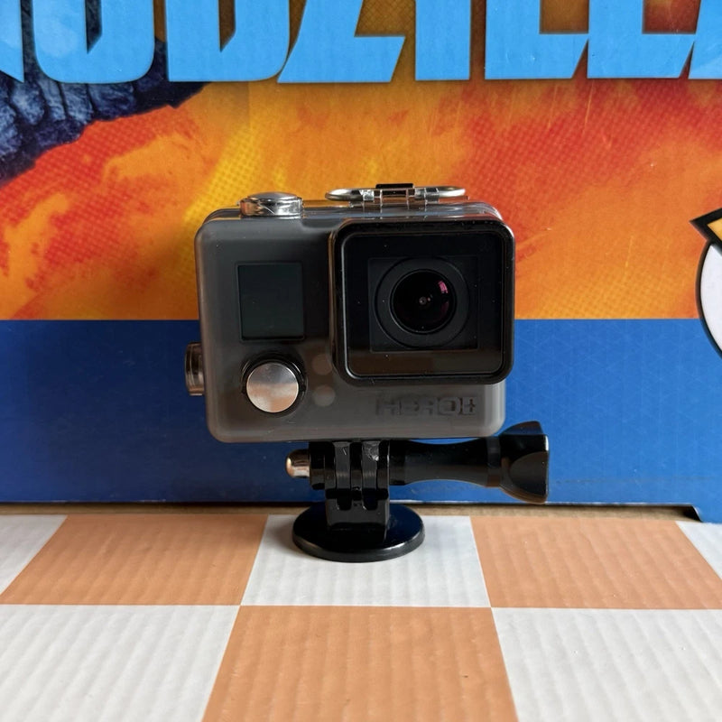 Action video camera in protective housing, front lens and status screen visible