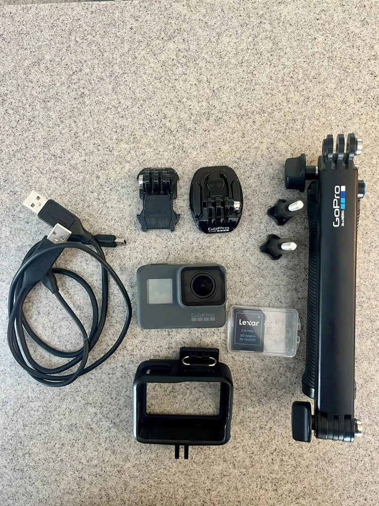 Black action camera bundle with GoPro camera, mounts, cable, battery case, and protective housing