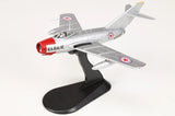 Grey MiG-15 Fagot model airplane with red nose and black display stand