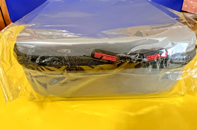 Yellow zippered drone carrying case with interior mesh pocket, wrapped in plastic