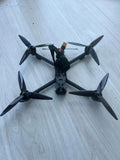 Black FPV quadcopter drone with four propellers, viewed from above