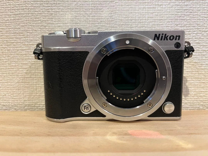 Nikon 1 J5 digital camera with silver body, black grip, front lens mount