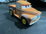 Smokey plastic model car with blue eyes and tan truck body