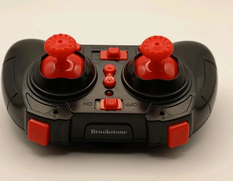 Mini quadcopter remote controller, black with red joysticks and Brookstone label
